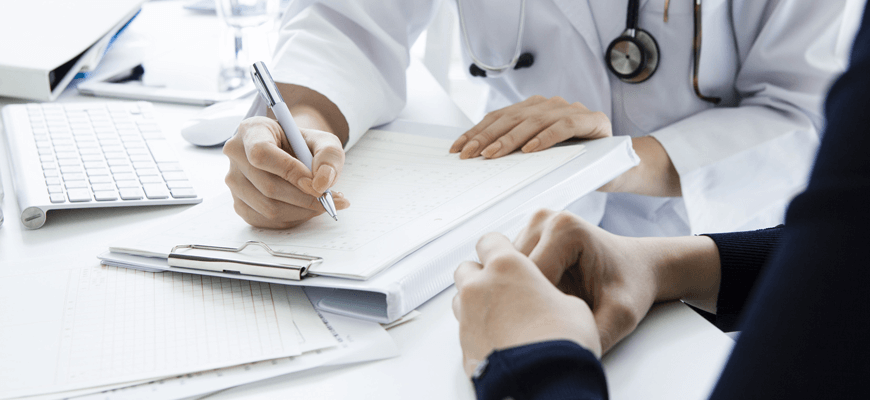 Palisades Vein Center - doctor writing on a clipboard sitting with patient